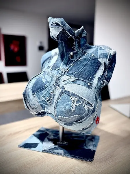 Buste sculpté habillé de morceaux de jean, posé sur un socle